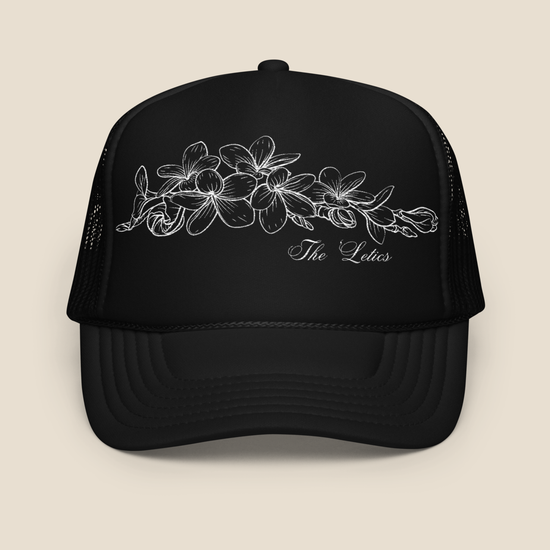 Black foam trucker hat with embroidered Champei or also known as Plumeria flower, front view.